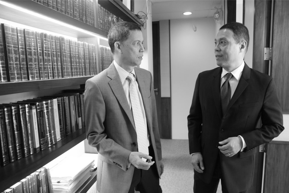 Mendoza & Pangan partners chatting by bookshelf.